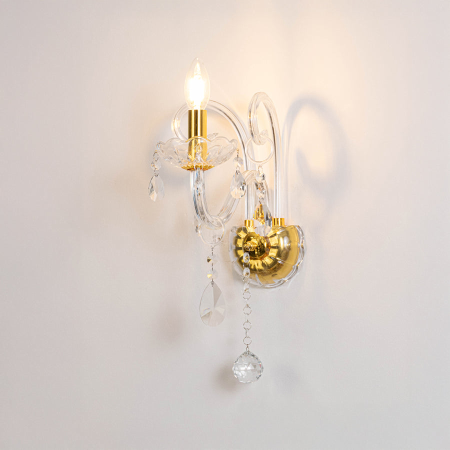 Modern crystal wall light in gold finish with hanging crystals for bedroom or living decor lighting white background.