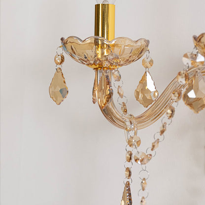 Closeup of golden wall light with crystal drops dual candle style decorative wall mounted lighting for interiors.