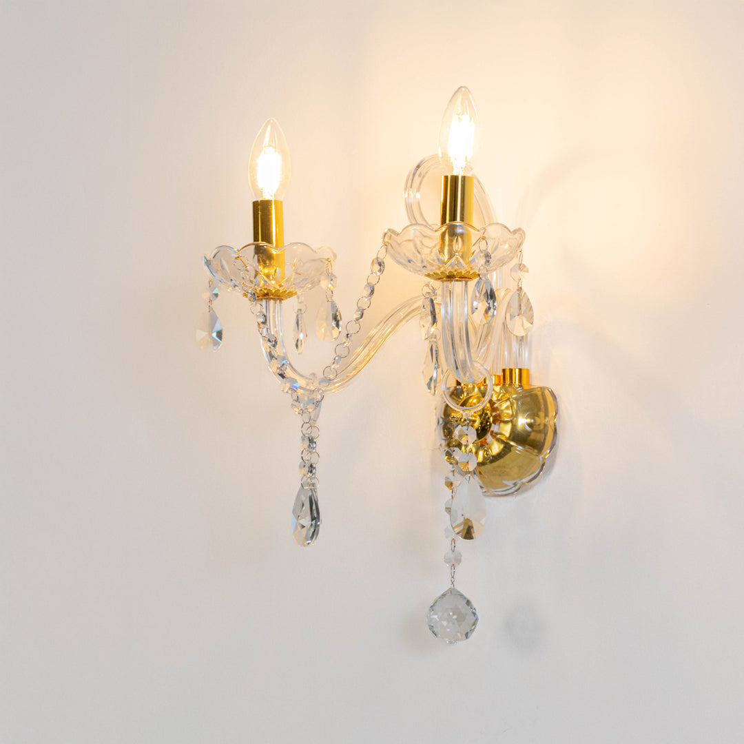 Elegant crystal wall light in gold finish with hanging crystals for bedroom or living room decor lighting white background.