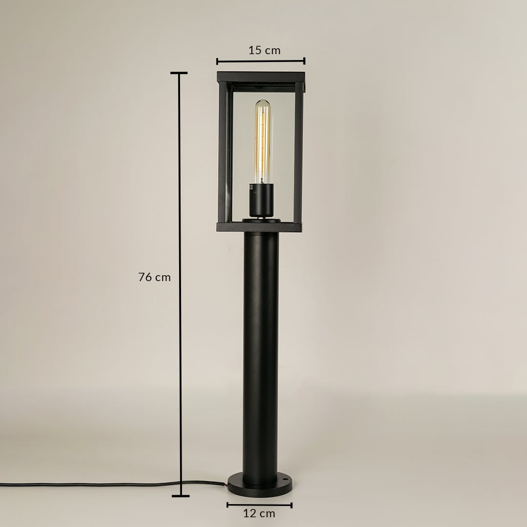 A black outdoor bollard light on a white background with dimensions marked showing 76 cm total height 15 cm top width and 12 cm base width providing precise size reference.