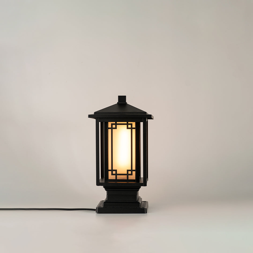 Black outdoor gate light with warm glowing bulb for elegant modern exterior decor styling use.