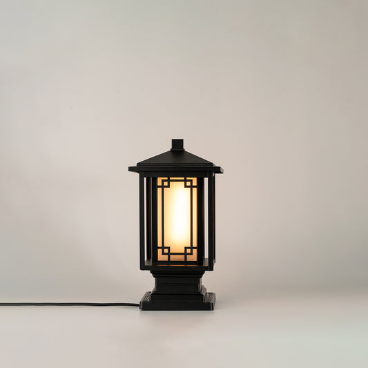 Black outdoor gate light with warm glowing bulb for elegant modern exterior decor styling use.