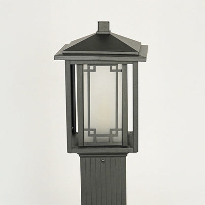Close view of outdoor pole light with black metal body and glass enclosure showcasing durable weather resistant lighting design.