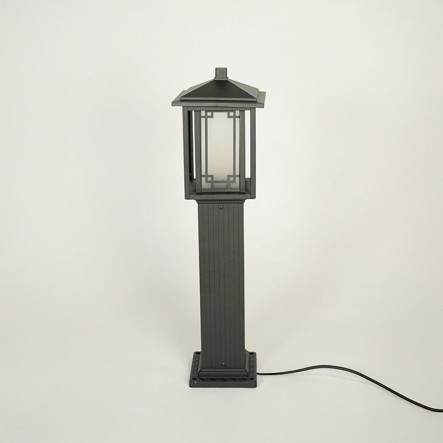 Modern outdoor bollard light with metal frame and clear glass panels on clean background perfect for exterior landscape lighting.