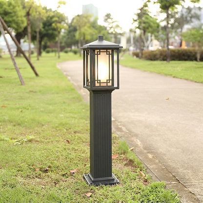Outdoor garden pole light with matching bronze lantern design installed along pathway ideal for cohesive landscape lighting setup.

