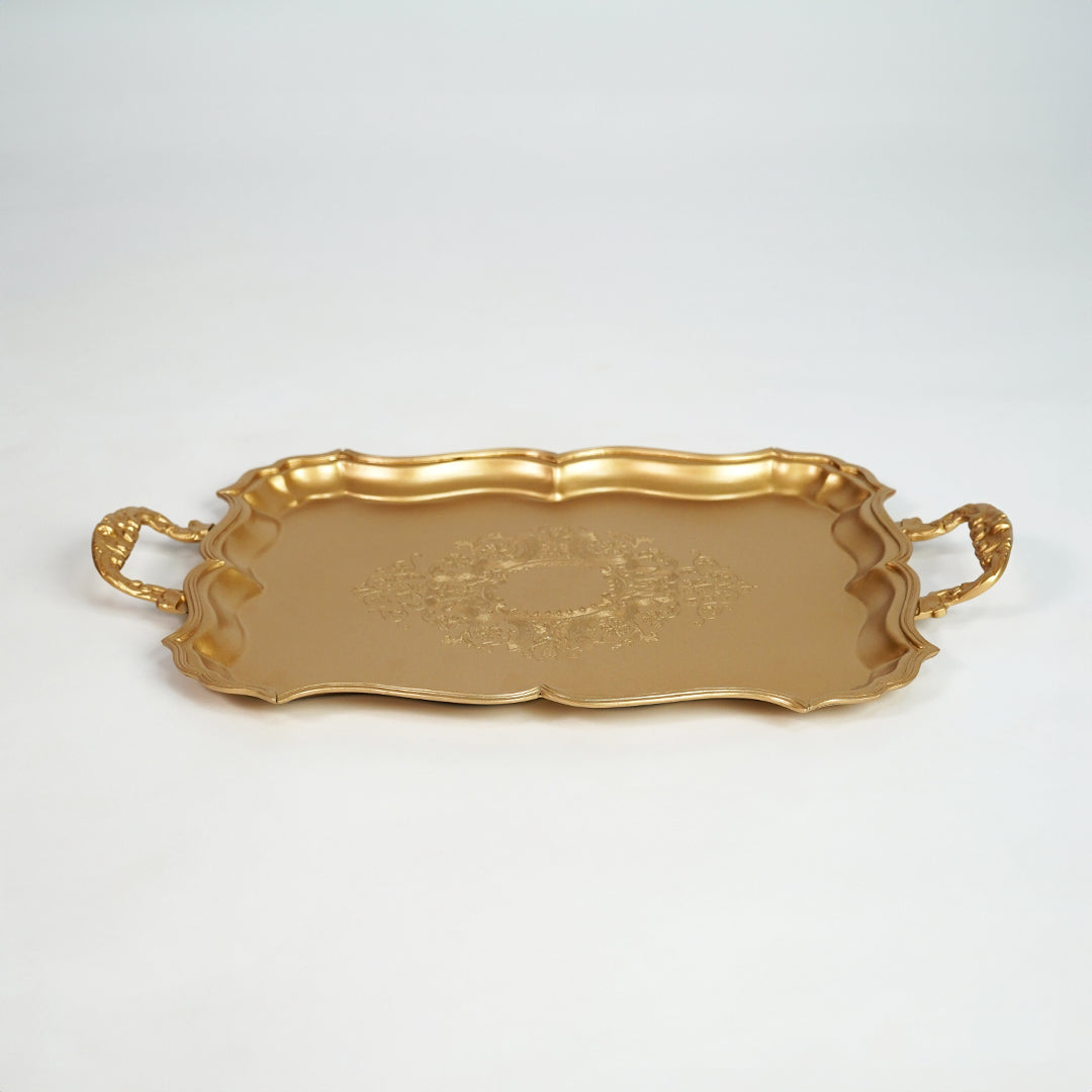 Elegant gold metal serving tray with ornate handles for dining table and home decor on white background image.