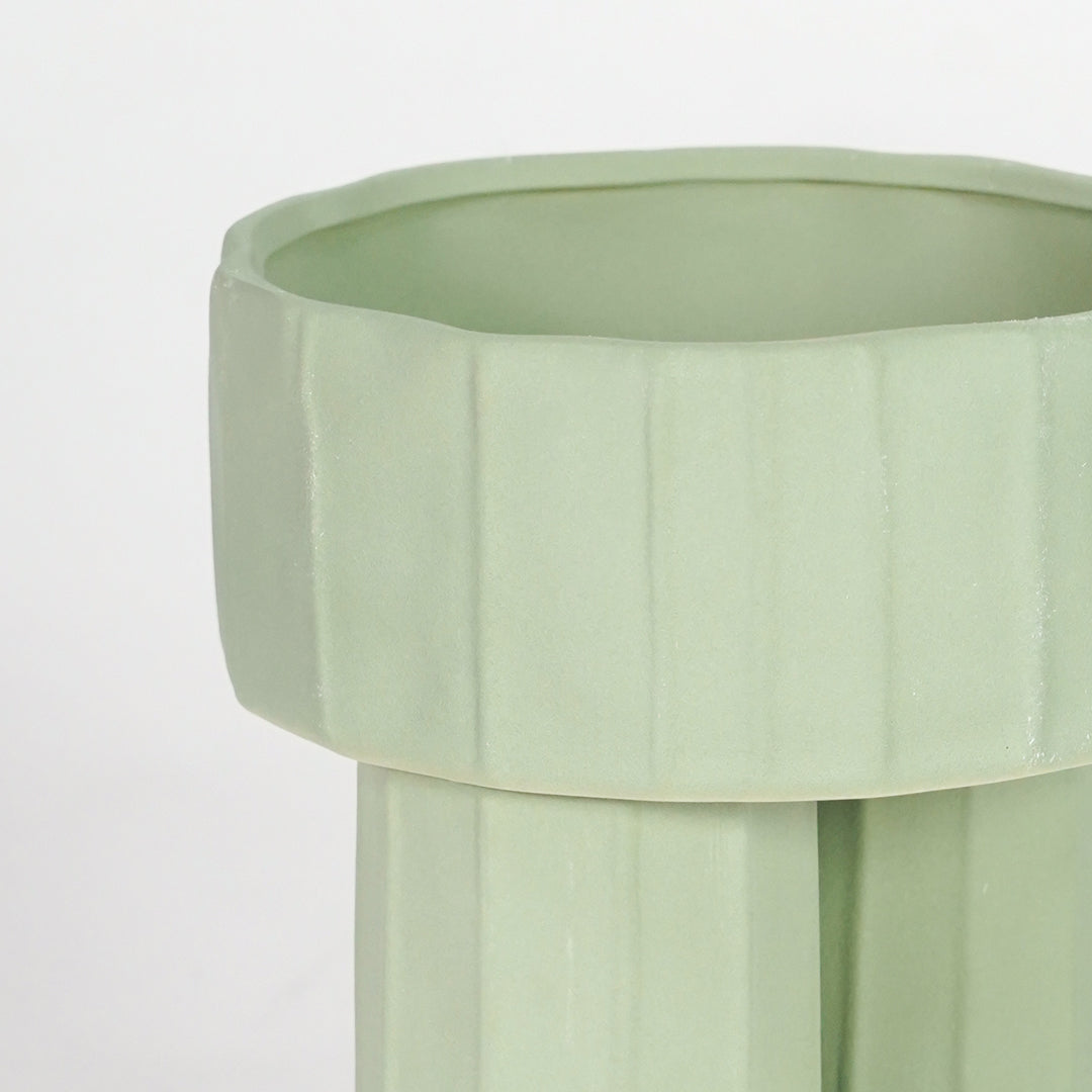 Closeup image of green ceramic modern vase for elegant console table decor styling with ribbed matte finish.