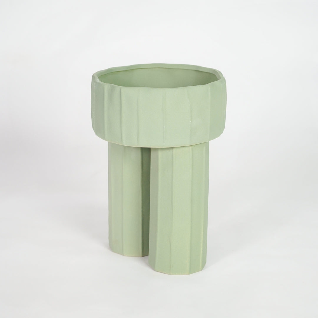 Green ceramic planter pot for modern shelf placement and elegant indoor home decor styling accent piece.