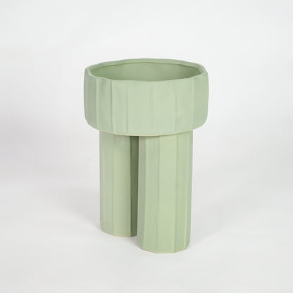 Green ceramic planter pot for modern shelf placement and elegant indoor home decor styling accent piece.