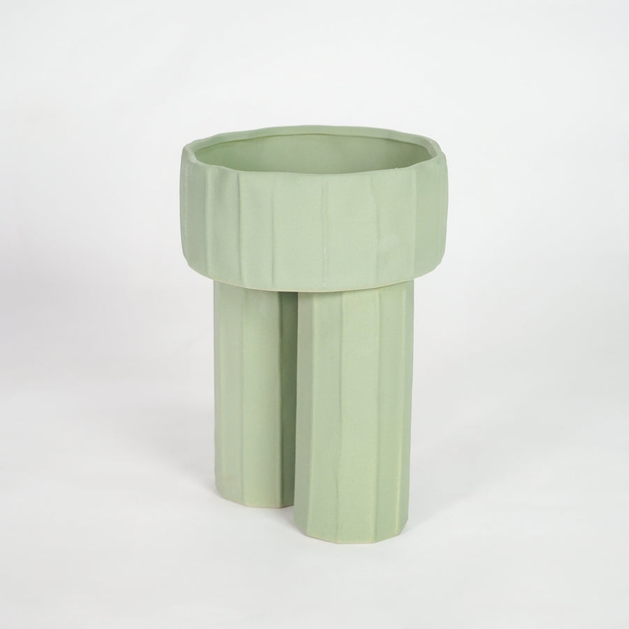 Green ceramic planter pot for modern shelf placement and elegant indoor home decor styling accent piece.