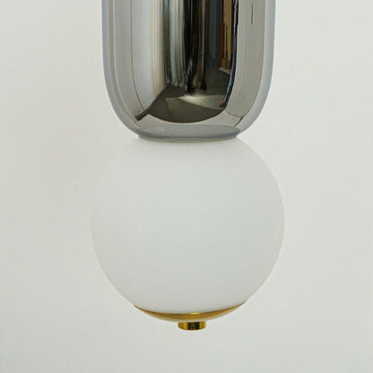 Closeup of chrome metal and white glass pendant light highlighting reflective finish and craftsmanship.