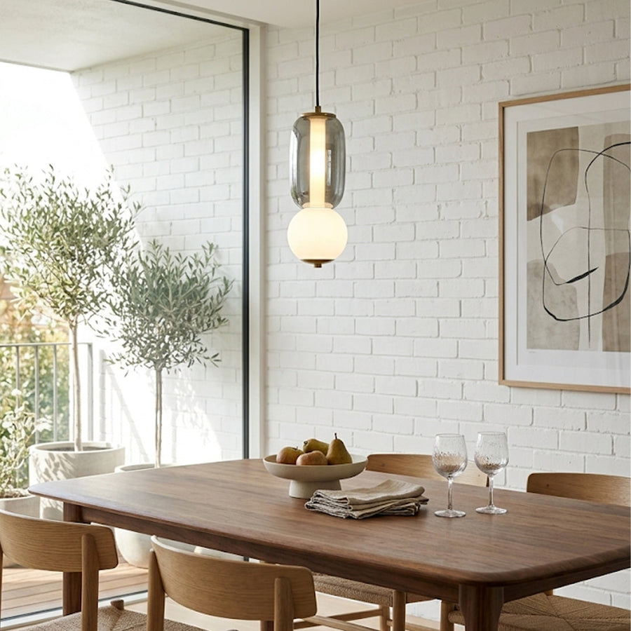 Mixed glass pendant lights creating cozy ambience above the kitchen island in contemporary interiors.