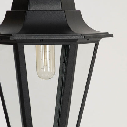 Classic black hanging lantern glowing on white background highlighting detailed frame and glass clarity.
