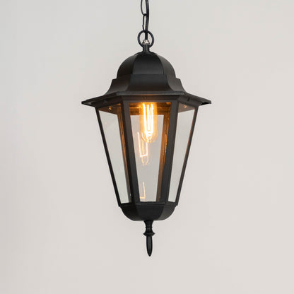 Black metal hanging lantern light with warm glow and clear glass panels for elegant outdoor decor.