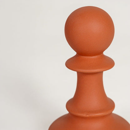 Closeup of matte terracotta ceramic vase with smooth rounded detailing ideal for elegant home decor shelf styling.