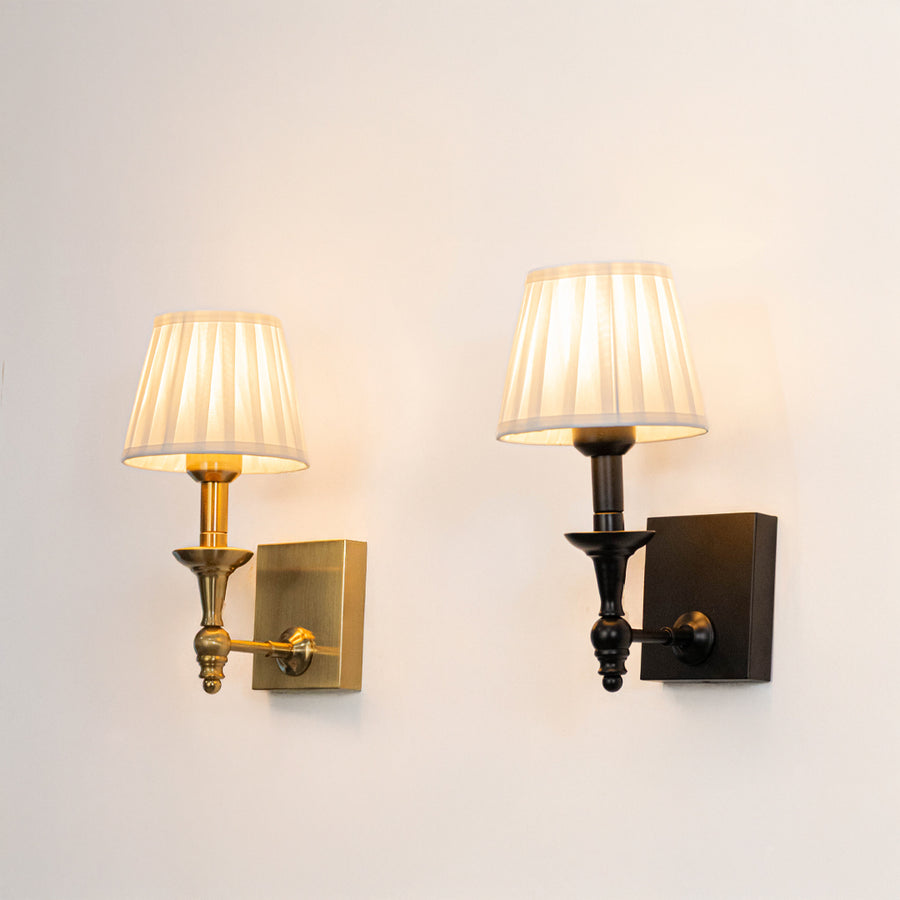 Modern wall light set in black and gold metal finish with fabric shades for bedroom or living decor lighting placement white background.