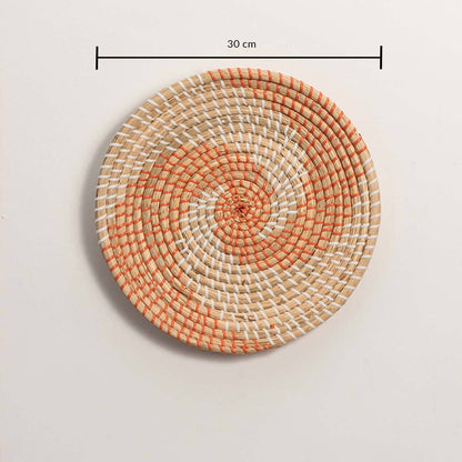 Dimension image of handcrafted natural cream seagrass wall basket with orange woven spiral wave pattern for boho decor display.