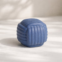 Blue ceramic textured decorative sphere placed on table adding playful and modern accent to living room decor.