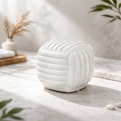 White ceramic textured decorative jar placed on coffee table creating soft and elegant home decor accent.
