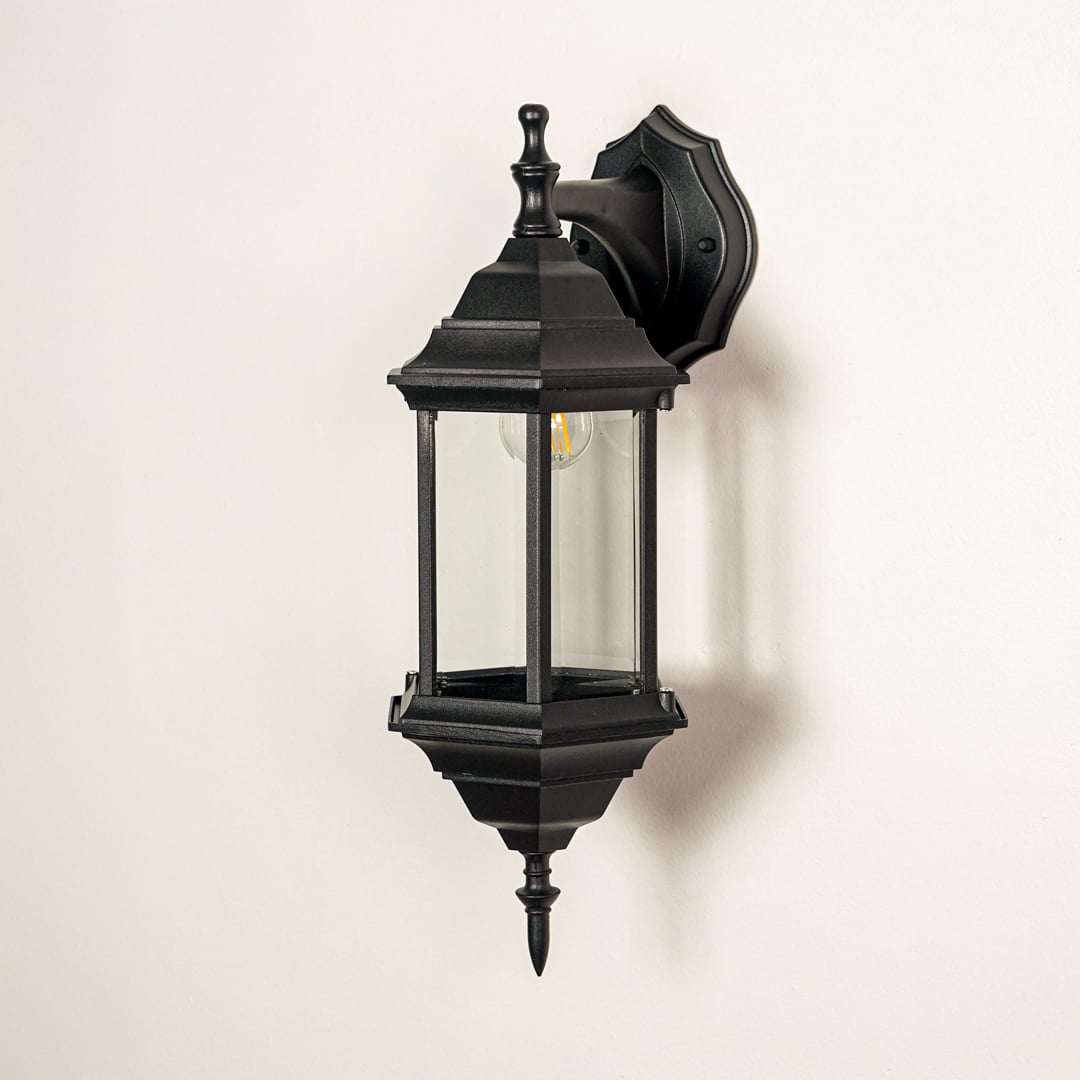 Black metal outdoor wall lantern with clear glass panels for modern exterior lighting decor placement styling.