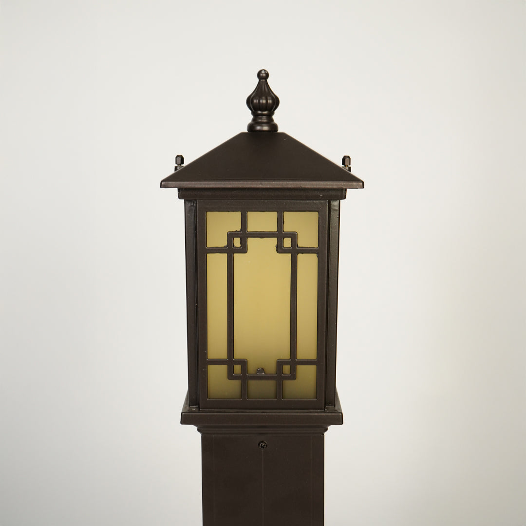 Close view of outdoor lantern pole light with warm glass glow showcasing durable weather resistant exterior lighting design.

