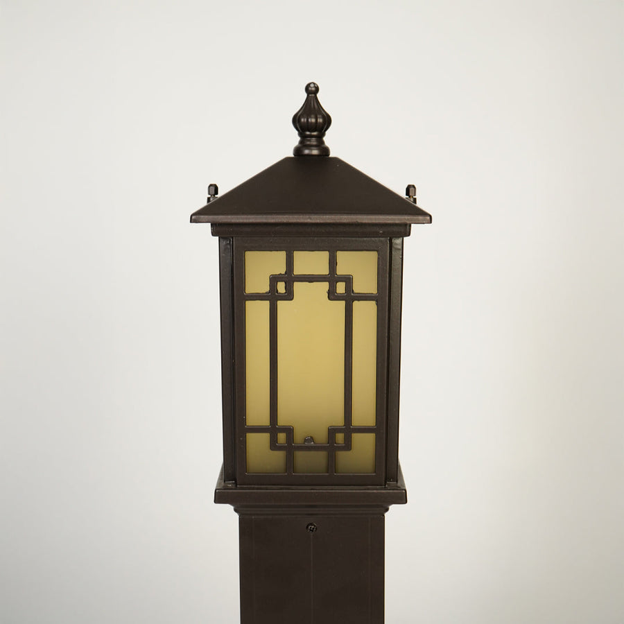 Close view of outdoor lantern pole light with warm glass glow showcasing durable weather resistant exterior lighting design.

