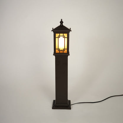 Traditional outdoor bollard light with black metal frame and glass panels on clean background perfect for exterior home lighting.