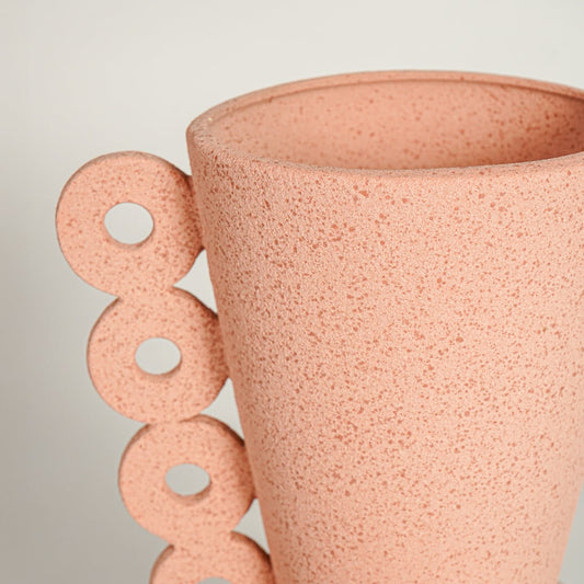 Close up view peach textured ceramic vase showing speckled surface sculpted form decorative ceramic accent for home styling.