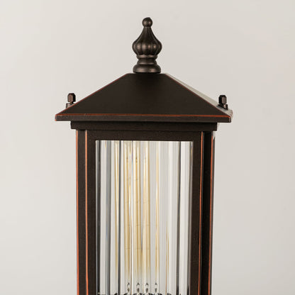 Black outdoor lantern Closeup Light On showing the ribbed glass texture and the bright vertical filament bulb.