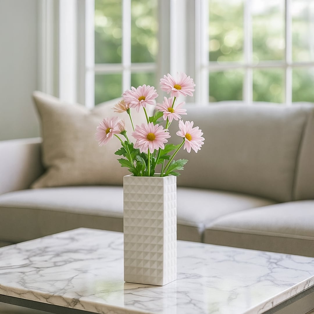 White geometric ceramic vase styled on a soft surface adding a clean modern accent perfect for living room shelves and console decor.