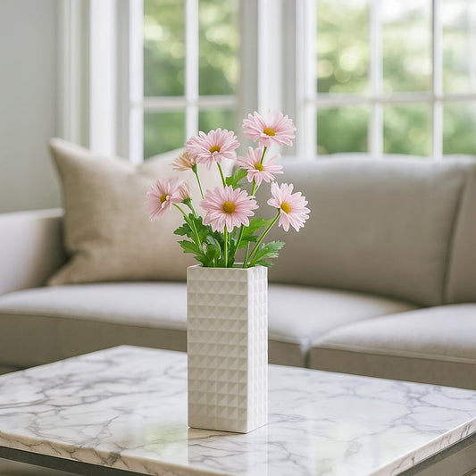 White geometric ceramic vase styled on a soft surface adding a clean modern accent perfect for living room shelves and console decor.