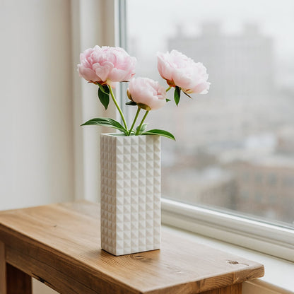 White textured ceramic vase styled on a clean surface adding a minimal modern accent suitable for shelves consoles and living room decor.