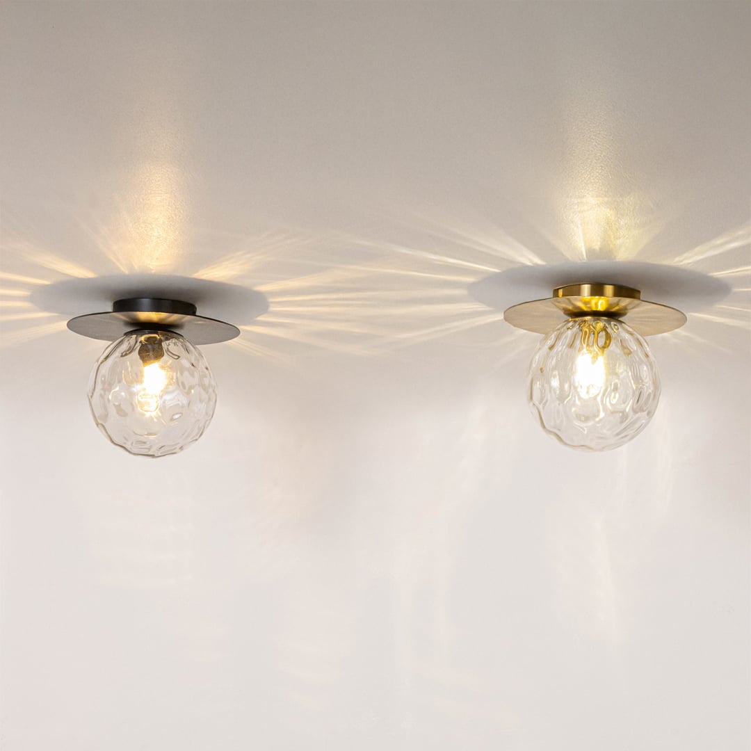 Black and gold ceiling lights with glowing textured glass globes displayed on white background for modern home lighting.