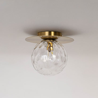 Gold ceiling light with textured glass globe and round frame in off mode displayed on white background for ceiling decor.