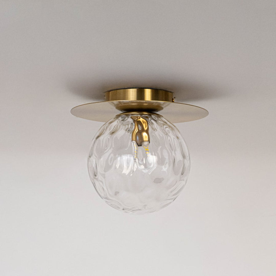 Gold ceiling light with textured glass globe and round frame in off mode displayed on white background for ceiling decor.