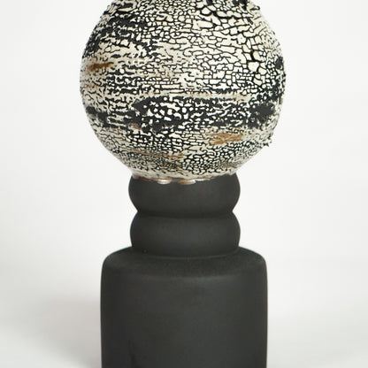Closeup image of black ceramic table lamp with textured glass shade for modern bedside decor styling and elegance.