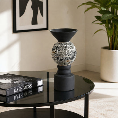 Black textured metal candle holder placed on side table for stylish contemporary home decor styling.