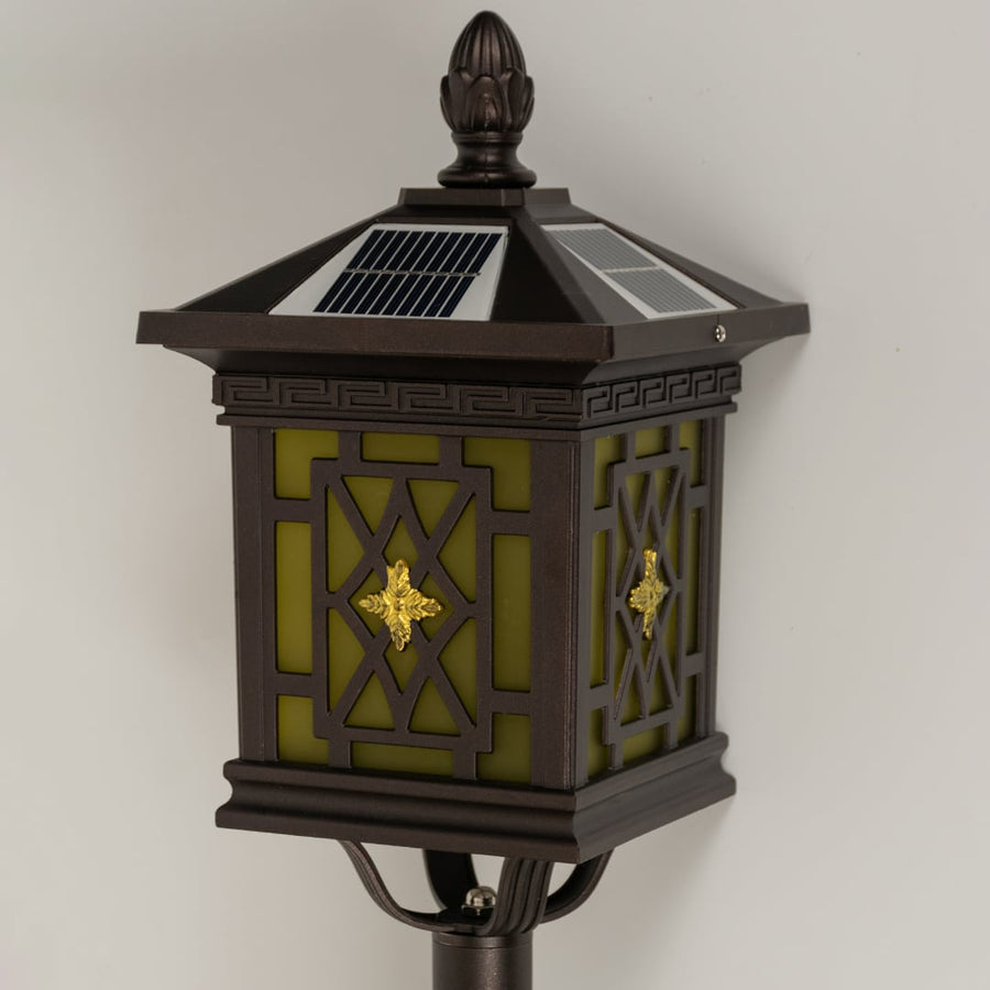 Closeup of brown solar garden lantern showing patterned glass panels and classic carved detailing ideal for warm decorative outdoor lighting.
