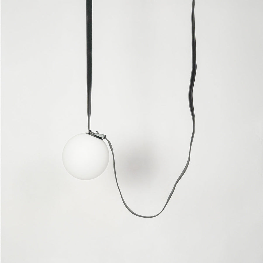 White globe glass pendant light with exposed black cord creating a minimalist contemporary look.