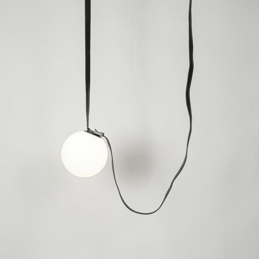 White glass pendant light with black fabric cord designed for stylish modern home decor spaces.