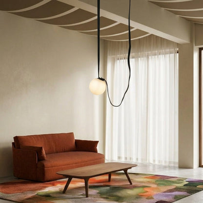 White glass pendant lights with black cords adding artistic elegance to contemporary living room interiors.
