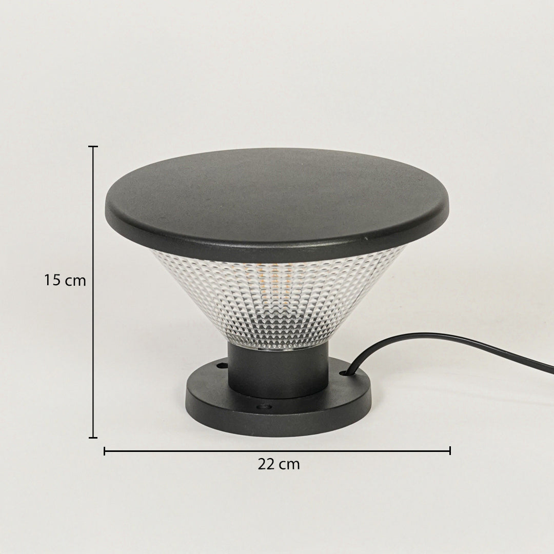 Contemporary outdoor surface light with black metal top and textured glass diffuser on neutral background 15 cm height 22 cm width ideal for garden or pathway lighting.

