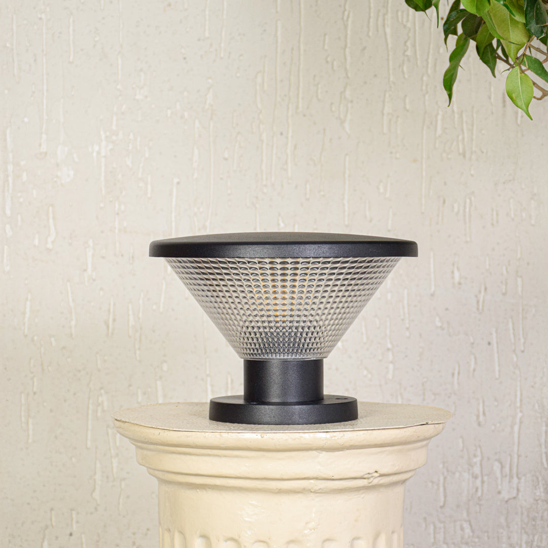 Modern outdoor pillar light with conical textured glass shade installed on exterior wall creating soft ambient lighting for outdoor decor.