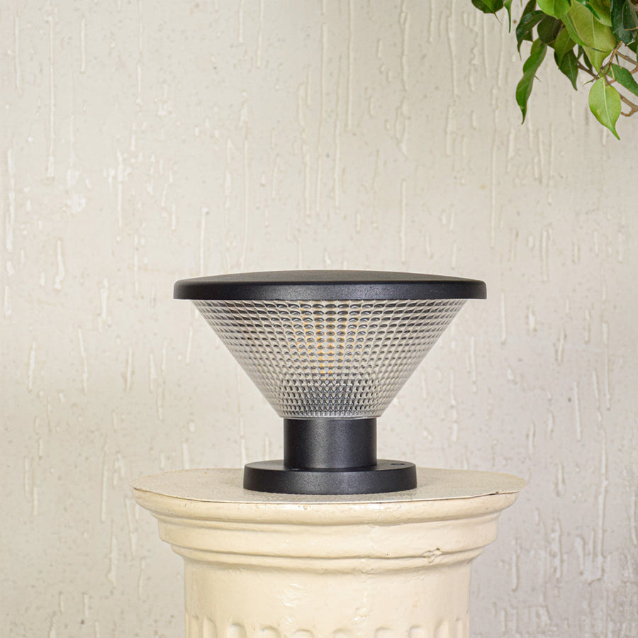Modern outdoor pillar light with conical textured glass shade installed on exterior wall creating soft ambient lighting for outdoor decor.