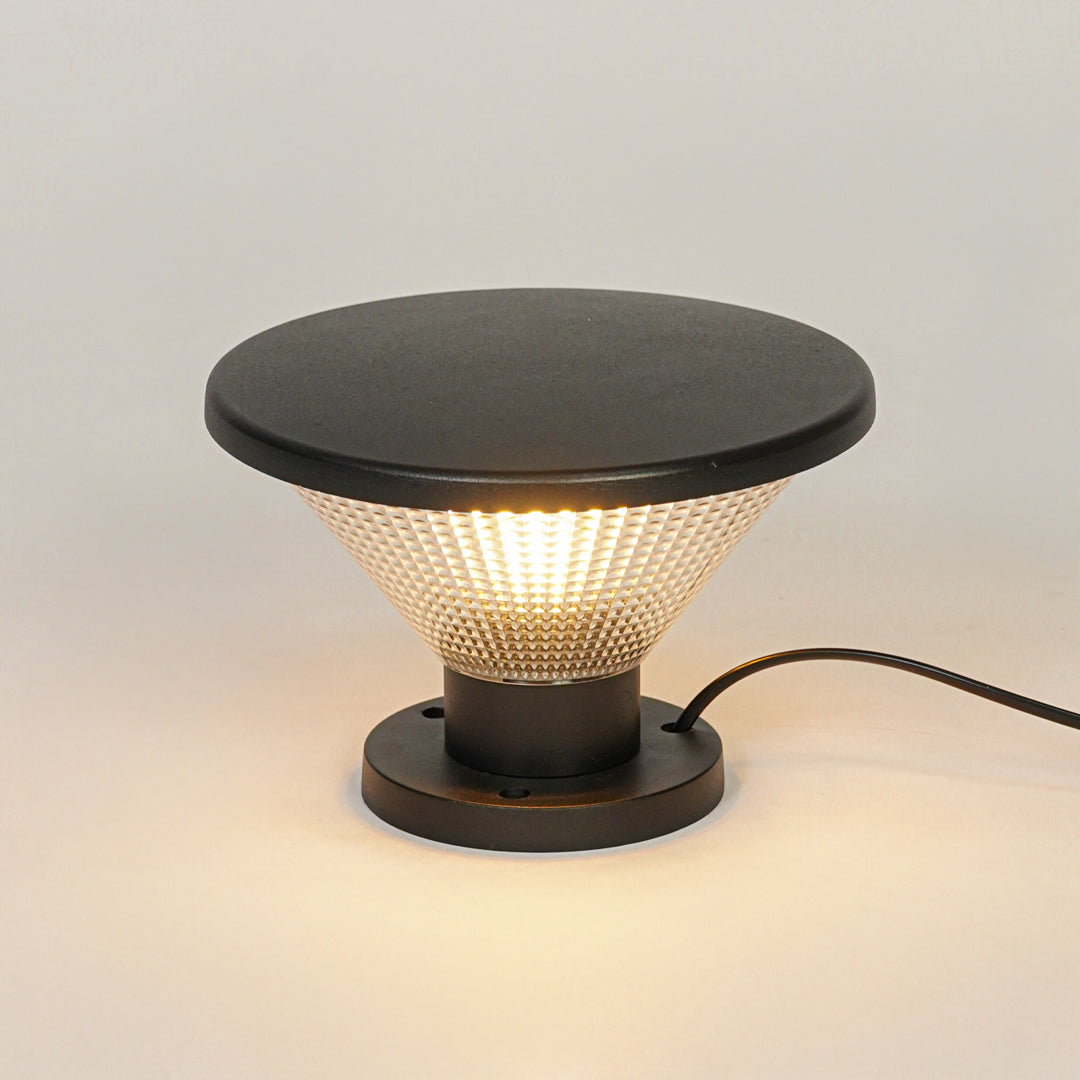 Outdoor pillar light with black metal top and textured glass diffuser on neutral background ideal for modern garden or patio lighting.