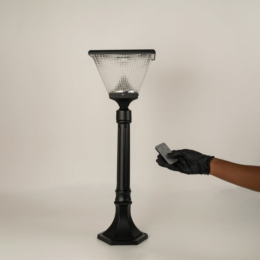 Black solar outdoor street light with textured glass shade and remote control for modern decor styling.
