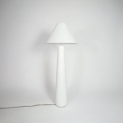 Table lamp with white fabric shade and sleek white base placed on neutral background ideal for modern bedroom or living room decor lighting.