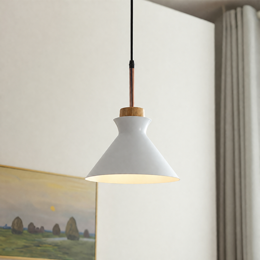 A modern pendant light with a white conical shade, a light wood accent ring, and a copper-colored rod, hanging against a neutral wall in an interior setting.