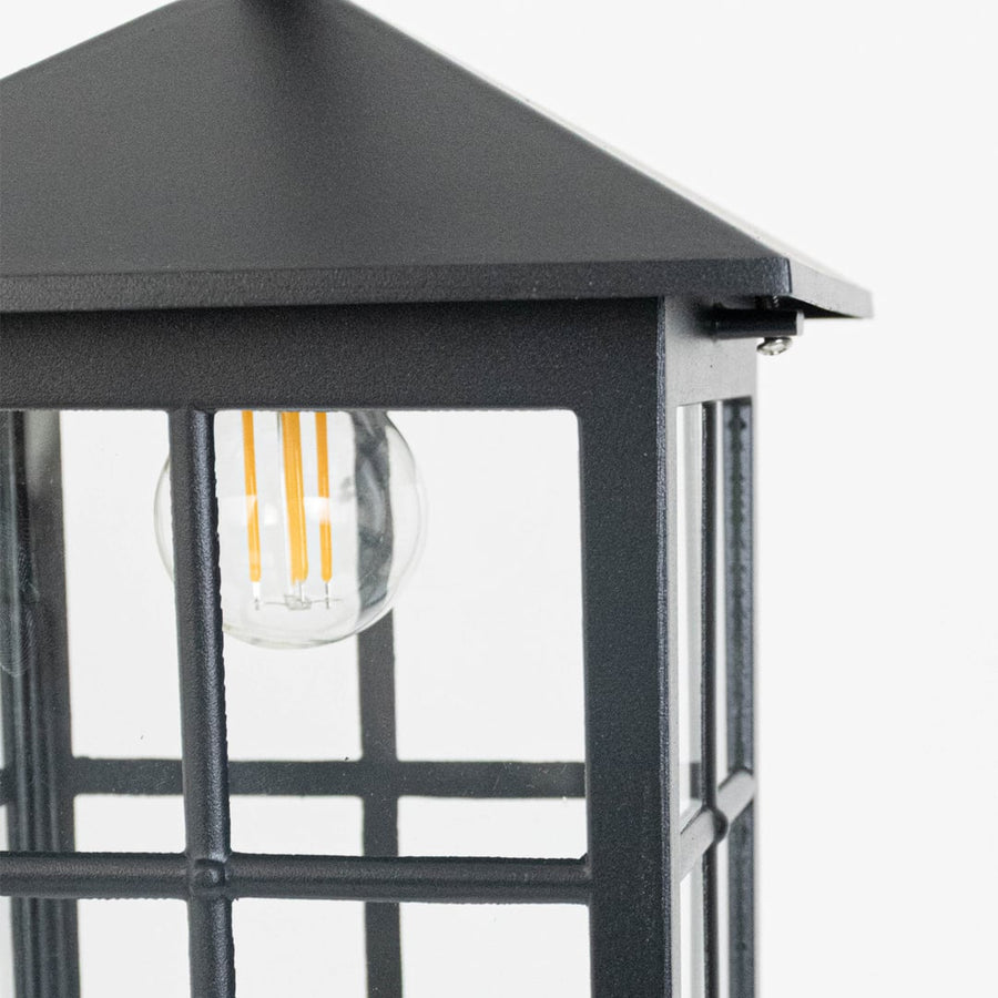 Detailed view of black lantern light highlighting pyramid top and clear glass sides.