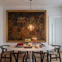 Amber glass globe pendant light with black metal accents illuminating dining room with warm modern elegance.
